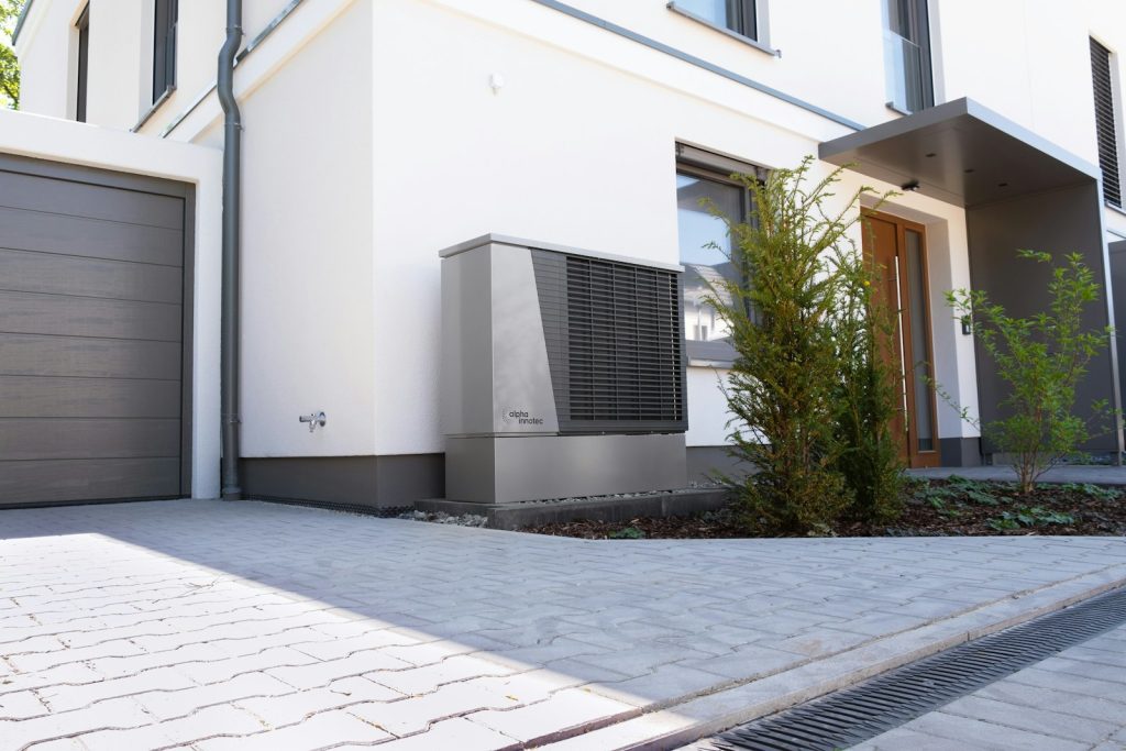Unité extérieure d'une pompe à chaleur devant une maison individuelle