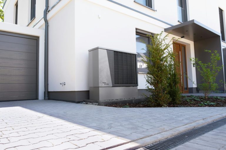 Unité extérieure d'une pompe à chaleur devant une maison individuelle